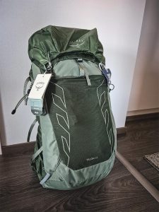 Uusi vihreä Osprey Talon 33 -reppu tuotelapuilla kuvattuna sisätiloissa.