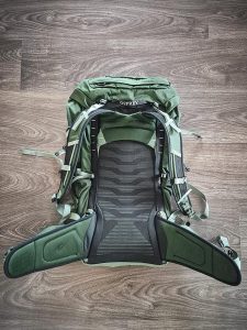 Osprey Talon 33 -repun selkäpuoli ja säädettävät olka- sekä lantiovyöt esillä lattialla.