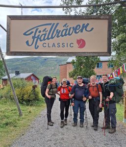 Viisi vaeltajaa seisoo Fjällräven Classic -tapahtuman portin alla lähtöalueella.