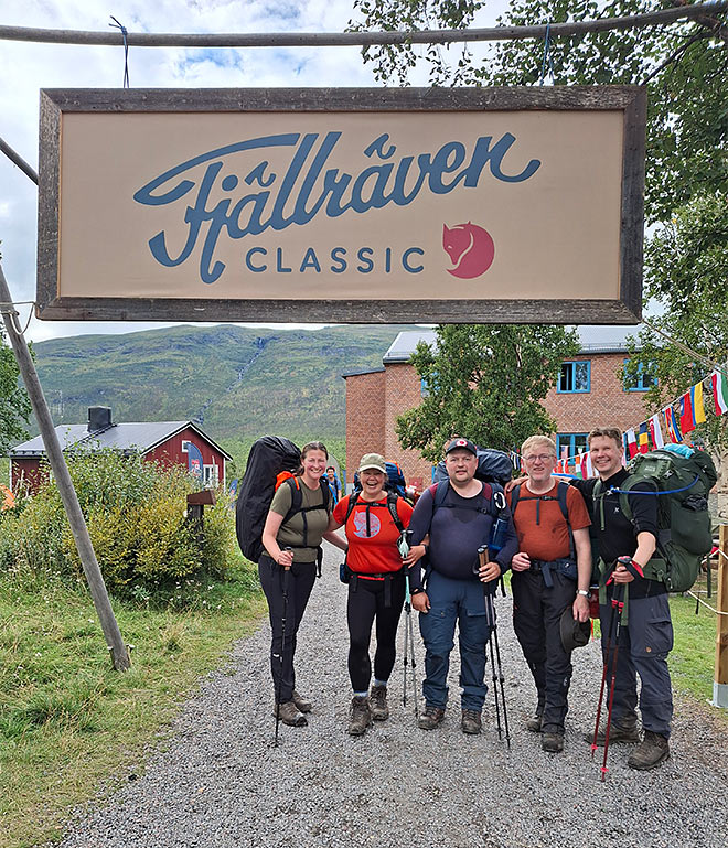 Viisi vaeltajaa seisoo Fjällräven Classic -tapahtuman portin alla lähtöalueella.