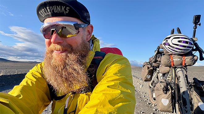 pyöräilijä ja lastattu bikepacking-pyörä islannin aurinkoisella ylängöllä.