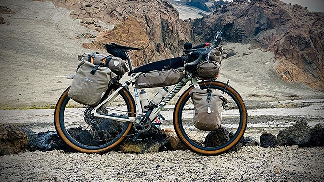 lastattu bikepacking-pyörä seisoo kivikkoisessa vuoristomaisemassa islannissa.