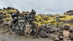bikepacking-varusteilla lastattu polkupyörä islannin karussa vuoristomaisemassa.