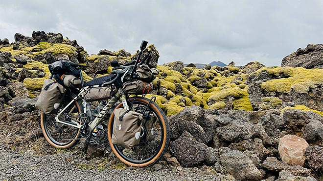bikepacking-varusteilla lastattu polkupyörä islannin karussa vuoristomaisemassa.